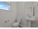 Powder room with pedestal sink, toilet, and small window at 20 Diamond Creek Dr, Zebulon, NC 27597