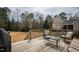 Wide angle of back deck with grill, chairs, and table with trees in background at 2016 Terri Creek Dr, Fuquay Varina, NC 27526