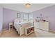 Cozy bedroom with a white bed frame, neutral carpet and a decorative chandelier at 2016 Terri Creek Dr, Fuquay Varina, NC 27526