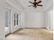 Spacious bedroom with a fan, neutral walls, and a glass door leading to the balcony at 222 Glenwood Avenue # 218, Raleigh, NC 27603