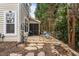 Cozy backyard stone patio with table and chairs, perfect for outdoor relaxation amid the trees at 2302 Wispy Green Ln, Raleigh, NC 27614