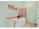 A well-appointed bathroom featuring a soaking tub, a glass-enclosed shower, and neutral tile flooring at 2302 Wispy Green Ln, Raleigh, NC 27614