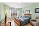Bright bedroom featuring a wooden bed frame, light green walls, and a large window at 2302 Wispy Green Ln, Raleigh, NC 27614
