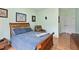 This bedroom features a wooden bed frame, blue bedding, and a view into the hallway at 2302 Wispy Green Ln, Raleigh, NC 27614
