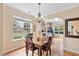 Bright dining area with hardwood floors, chandelier, and views of the landscaped yard at 2302 Wispy Green Ln, Raleigh, NC 27614