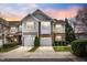 Charming townhome with a two-car garage and stone and siding exterior, set against a colorful sunset sky at 2302 Wispy Green Ln, Raleigh, NC 27614