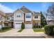 Beautiful townhome features a two-car garage, manicured landscaping, and a mix of stone and siding exterior at 2302 Wispy Green Ln, Raleigh, NC 27614
