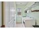 A functional laundry room featuring a washer and dryer, wire shelving, and natural light from a window at 2302 Wispy Green Ln, Raleigh, NC 27614
