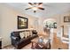 Spacious living room with hardwood floors, comfortable leather sofa, and arched entrance to dining area at 2302 Wispy Green Ln, Raleigh, NC 27614