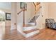 An inviting stairway featuring wood and white banisters, carpeted steps, and hardwood floors at 2302 Wispy Green Ln, Raleigh, NC 27614