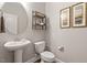Elegant powder room with pedestal sink, stylish decor, and modern fixtures at 244 Winding Oak Way, Clayton, NC 27520