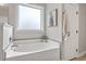 Bathroom showcasing a modern tub, tile accents, and a frosted window at 244 Winding Oak Way, Clayton, NC 27520