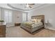 Spacious bedroom featuring tray ceilings, large windows with shutters, and plush carpeting at 244 Winding Oak Way, Clayton, NC 27520