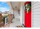 Charming front porch with a bright red door, decorative wreath and rocking chairs at 244 Winding Oak Way, Clayton, NC 27520