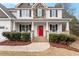 Close-up view of a charming front porch with a vibrant red door and classic white columns at 244 Winding Oak Way, Clayton, NC 27520