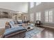 Open concept living room with hardwood floors, large windows, and neutral paint at 244 Winding Oak Way, Clayton, NC 27520