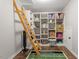 Storage room with shelving, a rolling ladder, dark floors and a sports-themed rug at 244 Winding Oak Way, Clayton, NC 27520