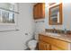 Bathroom with granite countertops, wood cabinets, and a window with natural light at 2501 Huntsman Trl, Zebulon, NC 27597