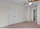 Bedroom with neutral carpet, ceiling fan, closet, and an additional door at 2501 Huntsman Trl, Zebulon, NC 27597