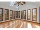 Bright bonus room featuring hardwood flooring, a ceiling fan, and numerous windows for natural light at 2501 Huntsman Trl, Zebulon, NC 27597