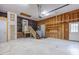 Spacious garage with lift, unfinished walls, and access door for customizing to your needs at 2501 Huntsman Trl, Zebulon, NC 27597