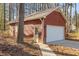 Red garage with white door and matching side door, nestled between trees at 2501 Huntsman Trl, Zebulon, NC 27597
