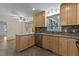 Well-lit kitchen features stainless steel dishwasher, granite counters, and light wood cabinets at 2501 Huntsman Trl, Zebulon, NC 27597