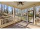 Screened-in porch with ceiling fan and views of the wooded backyard at 2501 Huntsman Trl, Zebulon, NC 27597