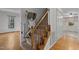 Carpeted staircase with a wooden banister featuring a lift for increased accessibility at 2501 Huntsman Trl, Zebulon, NC 27597