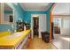 Retro bathroom with blue walls, yellow countertops, with closet space near a sliding glass door at 2503 Mckinney St, Burlington, NC 27217