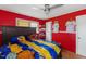 Red painted bedroom with a queen-sized bed, fan and natural light at 2503 Mckinney St, Burlington, NC 27217