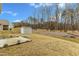 Backyard featuring a home's vinyl siding, a shed for storage, a concrete patio, and a serene view of bordering trees at 2728 Spring Valley Dr, Creedmoor, NC 27522