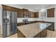 Modern kitchen with granite countertops, a stainless steel refrigerator, and dark wood cabinetry at 2728 Spring Valley Dr, Creedmoor, NC 27522