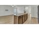 Kitchen island with granite countertop and wooden cabinets is surrounded by light wood-look flooring at 2728 Spring Valley Dr, Creedmoor, NC 27522