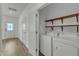 Convenient laundry area with washer, dryer, and open shelving for storage near front entry at 2728 Spring Valley Dr, Creedmoor, NC 27522