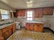 Dated kitchen featuring wooden cabinetry, a sink, and a window for natural light in need of repair at 306 Martin Luther King Jr Dr, Smithfield, NC 27577