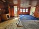 Wood-paneled living room featuring a vintage blue carpet and multiple doorways in need of repair at 306 Martin Luther King Jr Dr, Smithfield, NC 27577