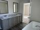 Bathroom showcases double vanity sinks, gray cabinets, and a separate tub room for modern convenience at 321 Duke Memorial Road, Louisburg, NC 27549