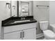 Bathroom with white cabinets, a black countertop, and modern fixtures over a marble style floor at 329 Umstead St, Sanford, NC 27330