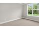 A well-lit bedroom with plush carpet and a large window providing views of the outside at 329 Umstead St, Sanford, NC 27330