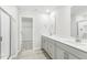Bathroom featuring double sink vanity, light wood look flooring and open walk-in closet at 3405 Rosebush Dr, Zebulon, NC 27597