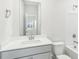 Clean bathroom features a white vanity, toilet, mirror, and combined shower/tub at 3405 Rosebush Dr, Zebulon, NC 27597