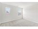 Bright bedroom featuring neutral-toned walls, plush carpet, and natural light from two large, view-framing windows at 3405 Rosebush Dr, Zebulon, NC 27597