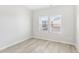 A bright bedroom with wood-look flooring, featuring two windows that allow natural light to illuminate the space at 3405 Rosebush Dr, Zebulon, NC 27597