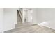 Bright living room featuring modern gray wood flooring, and staircase to the upper level at 3405 Rosebush Dr, Zebulon, NC 27597