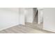 Spacious living room featuring wood-look flooring and a staircase with neutral walls; plenty of natural light at 3405 Rosebush Dr, Zebulon, NC 27597