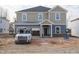 New two-story home with neutral siding, covered porch, and attached garage on an unfinished lot at 3837 Rosebush Dr, Zebulon, NC 27597