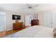 Bedroom with hardwood floors, TV, and a view into the ensuite bathroom at 4209 Converse Dr, Raleigh, NC 27609