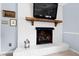 Close-up of the fireplace in the living room featuring a white brick surround and a rustic wood mantel at 4209 Converse Dr, Raleigh, NC 27609