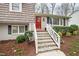 Inviting front porch with white railing leads to a vibrant red front door, enhancing curb appeal at 4209 Converse Dr, Raleigh, NC 27609